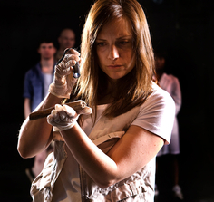 Nicole Perrone examines bones in "Wanderlust" at CPT (Photo Credit: Steve Wagner)